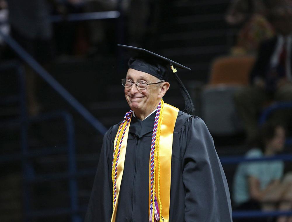 George Brady walks across the stage at the spring 2024 graduation ceremony at Wallace State Community College.